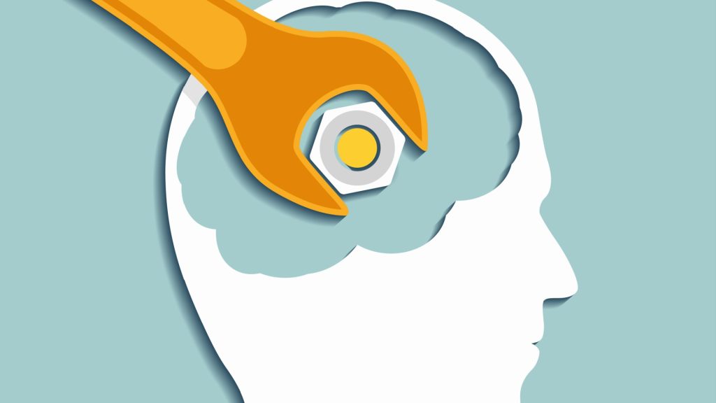 This image offers a visual metaphor that blends mechanical and cognitive elements. The outline of a human head is crisply defined in white against a muted, pale blue background, evoking a calm, contemplative atmosphere. Inside the head, where the brain would be, there is a gear and a wrench positioned as if the wrench is turning the gear. The gear, traditionally a symbol of machinery and systematic process, here represents the mind's workings—thought processes, problem-solving, or mental function. The wrench symbolizes intervention, adjustment, or repair, suggesting the idea of "tuning" or "fixing" one's mental state or thought patterns.