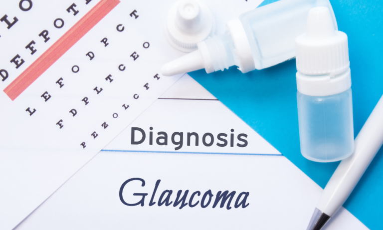 Close-up of medical documents related to glaucoma diagnosis. A piece of white paper with an eye chart (with lines and letters) is visible. Overlapping this paper is another sheet of white paper with the words "Diagnosis" and "Glaucoma" written in dark script. Small, clear plastic bottles of eye drops are positioned on the paper, along with a white pen. The background is a light teal/turquoise colour, likely a medical notebook cover. The image conveys the concept of an eye examination and diagnosis.