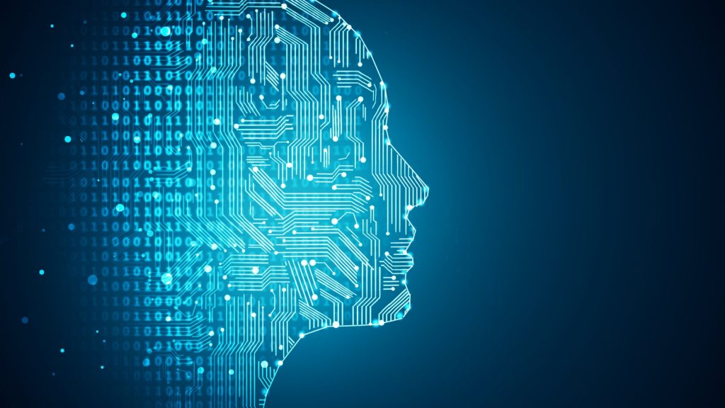 A profile view of a human head is depicted. The head is outlined with glowing, light-blue circuit board-like pathways. The background is a deep, dark teal/blue hue. Overlaid on the background are numerous binary code digits (1s and 0s) in a light, glowing, translucent blue, which fade out as they get further from the head's outline. The overlay of circuit lines and binary code creates an impression of artificial intelligence or technology.